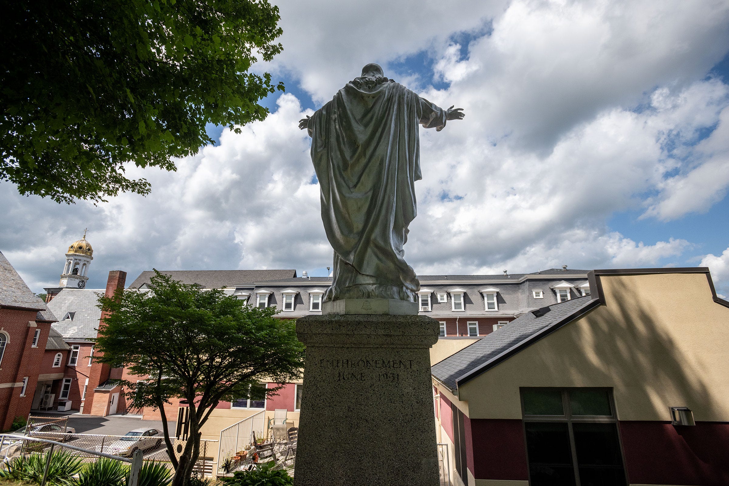 A statue overlooks the former mill village of Baltic, with St. Mary’s golden dome in the distance