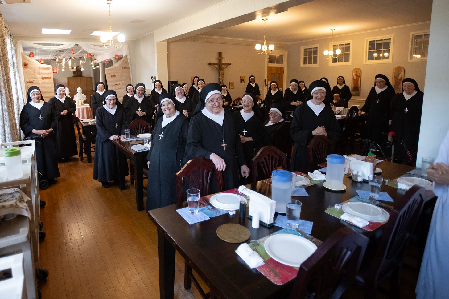 The Sisters gather joyfully around the tables of their dining room