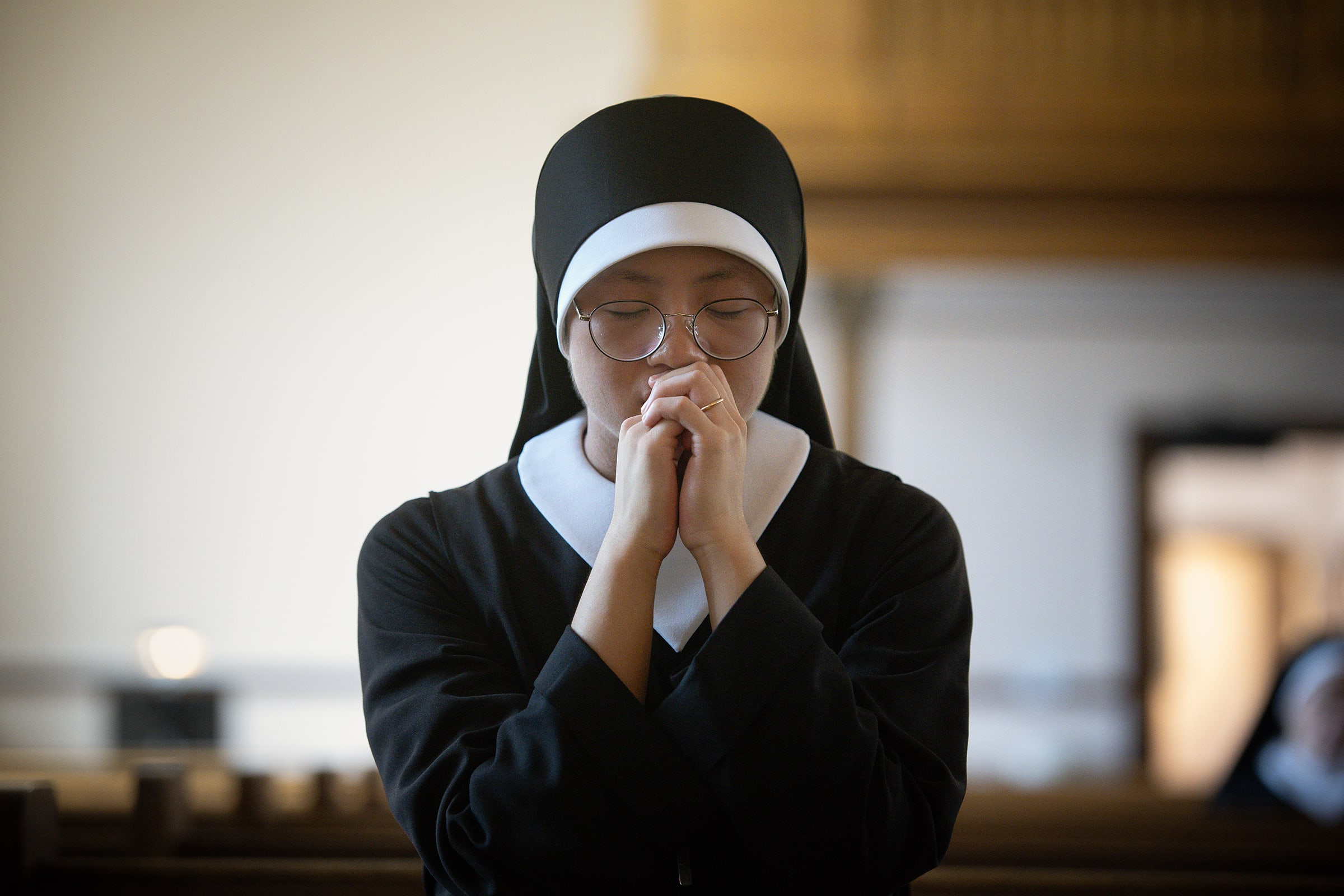 A young Sister prays with her eyes closed
