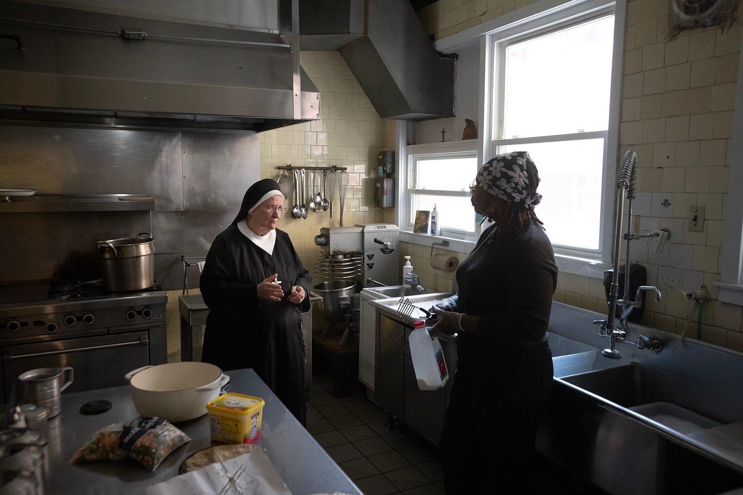 A Sister speaks with a visitor in the Motherhouse kitchen