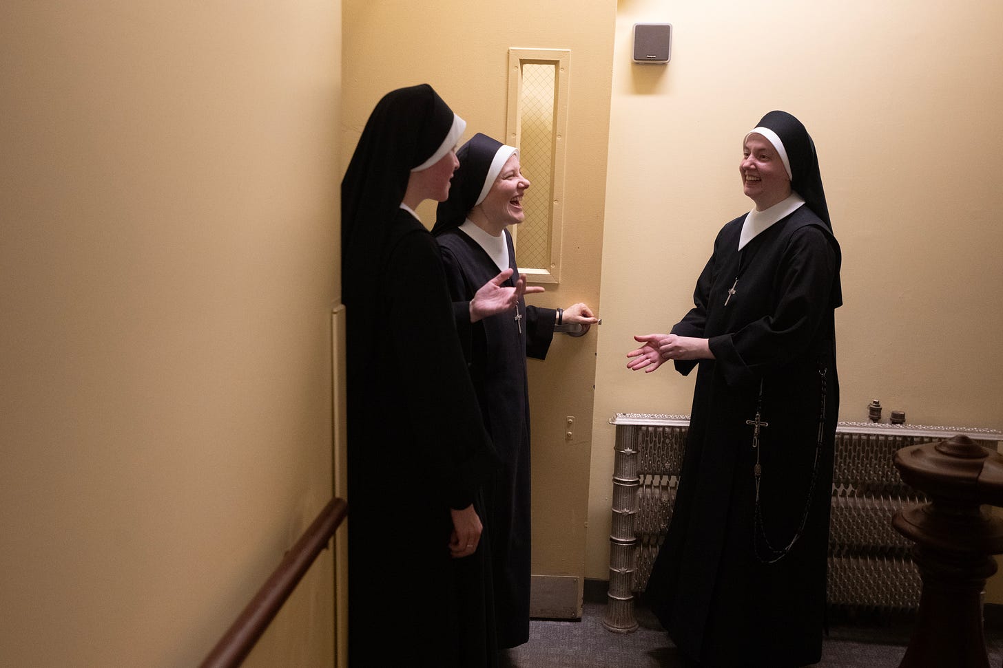 Three Sisters laugh together in a Motherhouse hallway