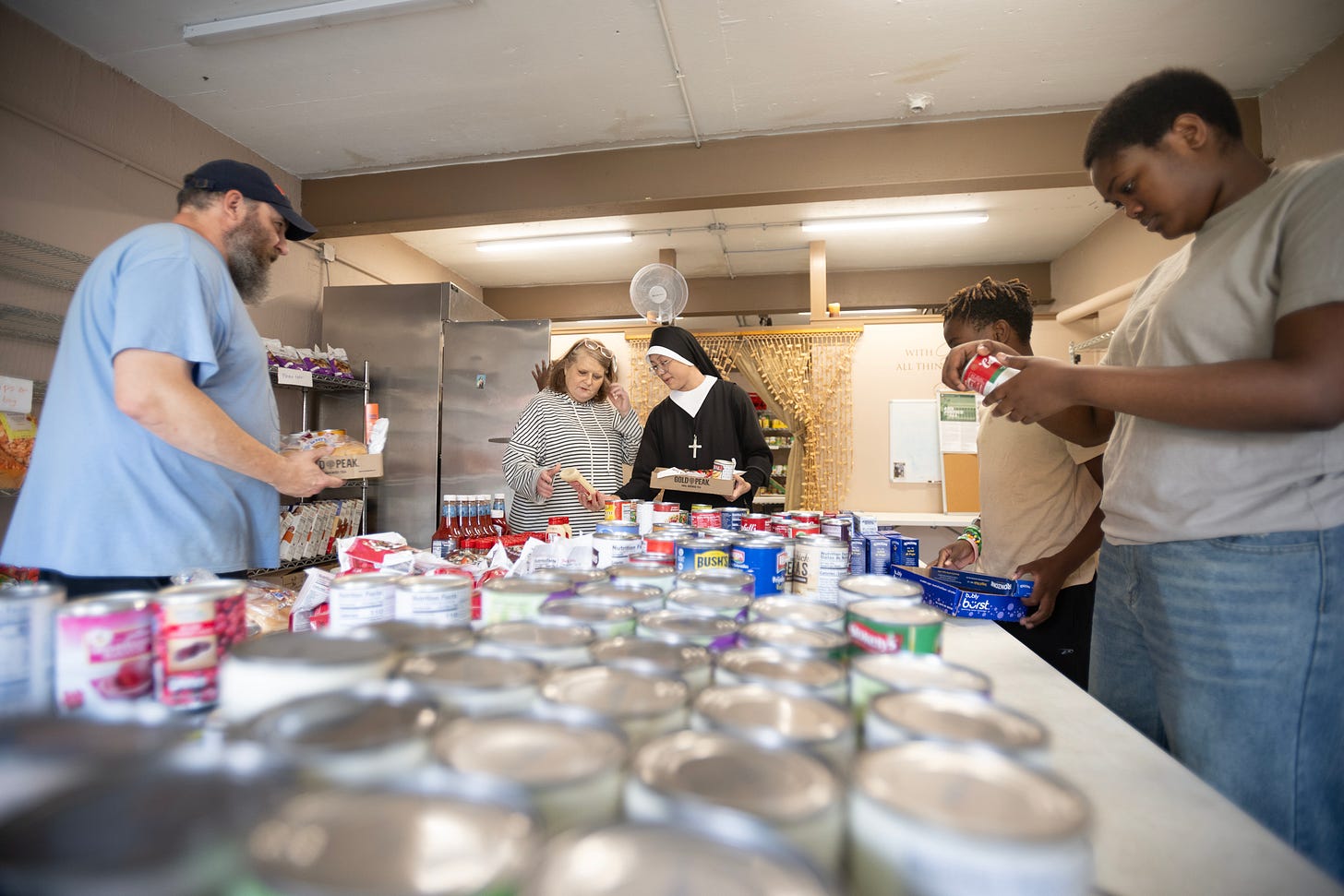 Volunteers and a Sister sort food in the community pantry