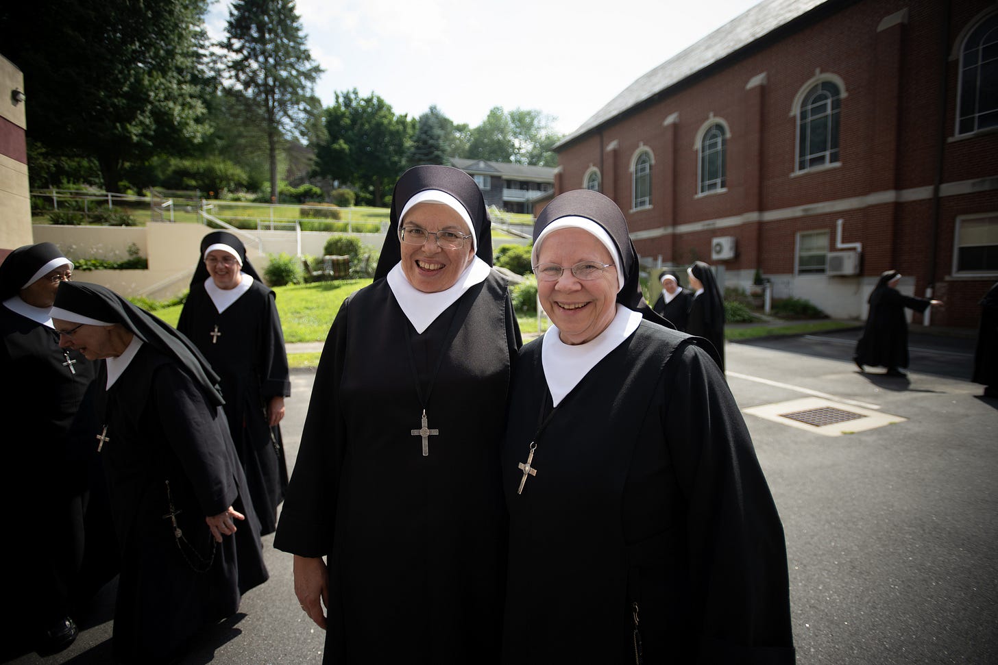 Four Sisters walk together beside the chapel