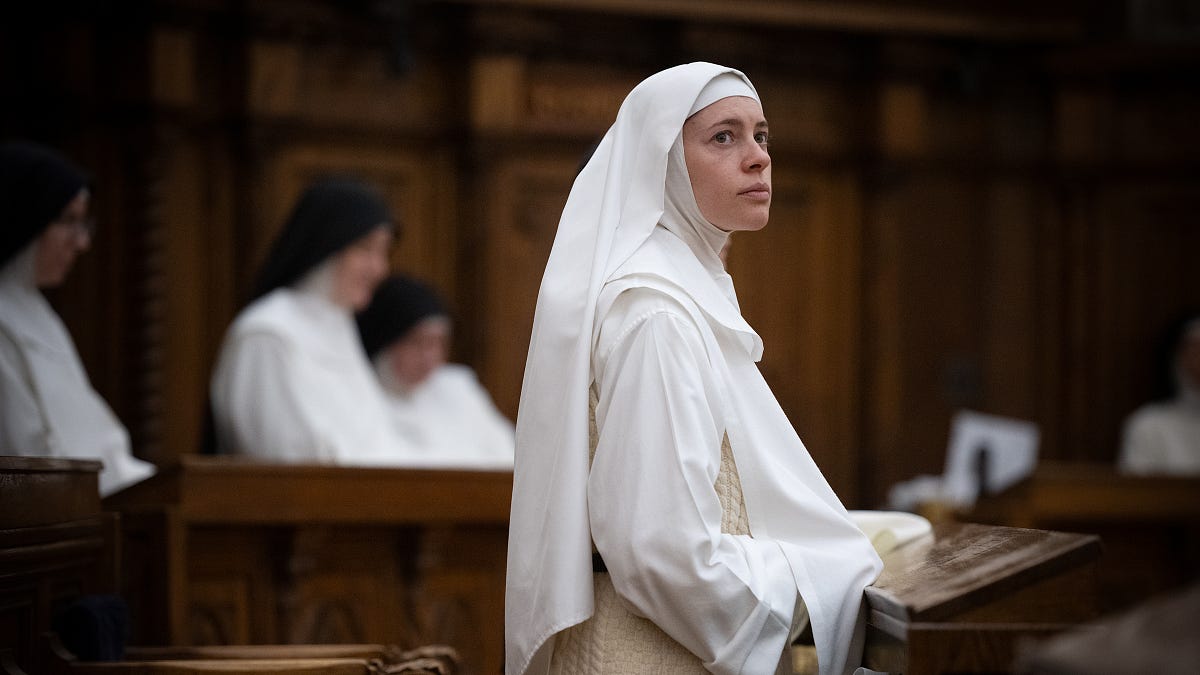 A Dominican nun in a white habit sits in the monastery chapel