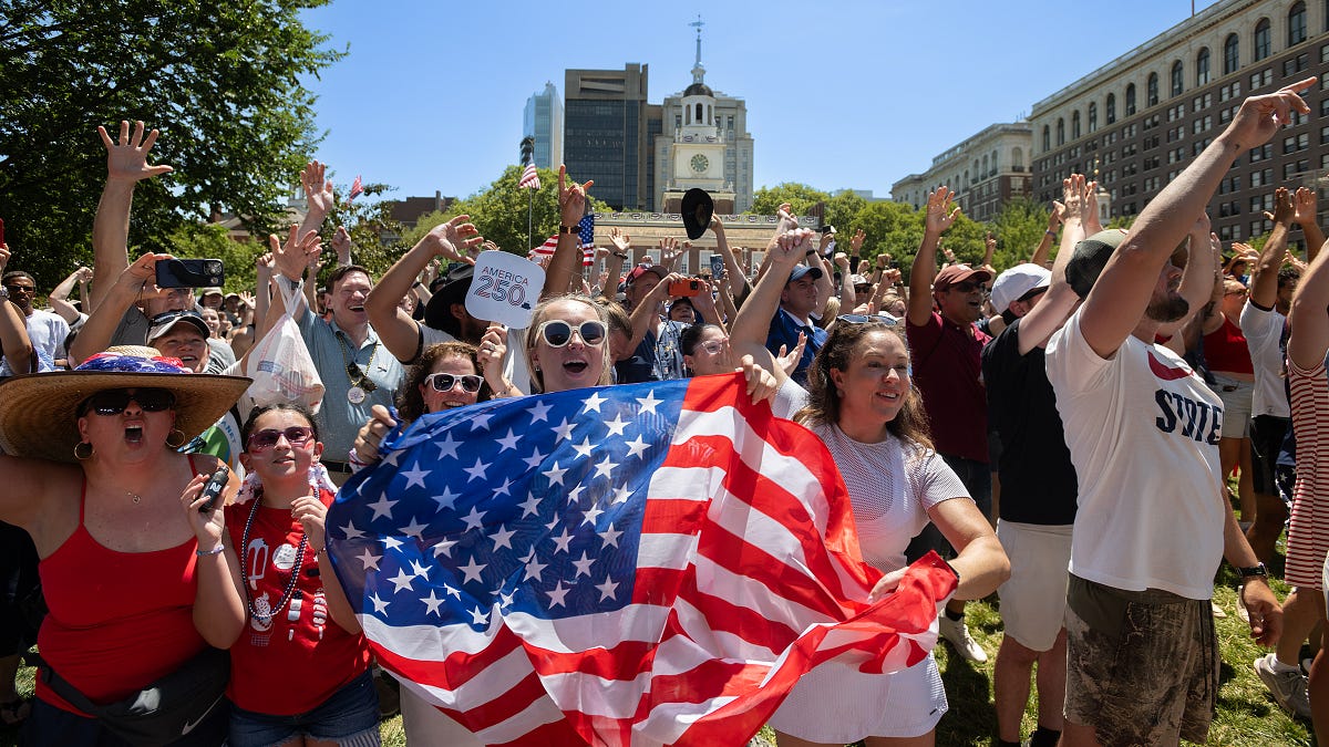 A jubilant crowd holds an American flag in front of Independence Hall in Philadelphia